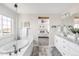 Primary bathroom featuring soaking tub, dual sinks, and wood-look tile floor at 7678 S Old Hammer Way, Aurora, CO 80016