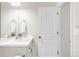 Bright, simple bathroom with a vanity, toilet, and ample lighting near a door at 7678 S Old Hammer Way, Aurora, CO 80016