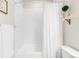 Clean, all-white bathroom with a shower-tub combo and simple, elegant decorative touches at 7678 S Old Hammer Way, Aurora, CO 80016