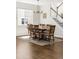 Sunlit dining room with hardwood floors, a modern chandelier, and a wooden table with seating for six at 7678 S Old Hammer Way, Aurora, CO 80016