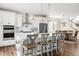 Well-lit kitchen boasts white cabinetry, stainless steel appliances, a large island, and seating for four at 7678 S Old Hammer Way, Aurora, CO 80016