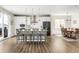 Bright kitchen with white cabinets, stainless steel appliances, large island with seating, and wood flooring at 7678 S Old Hammer Way, Aurora, CO 80016