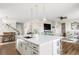 Open concept kitchen with large island, white cabinets, modern lighting, and seamless flow to the living area at 7678 S Old Hammer Way, Aurora, CO 80016