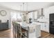 Bright, modern kitchen with a large island, white cabinets, stainless steel appliances and pendant lighting at 7678 S Old Hammer Way, Aurora, CO 80016