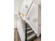 Elegant staircase featuring carpeted steps, white railings, and a high ceiling with natural light from skylight windows at 7678 S Old Hammer Way, Aurora, CO 80016