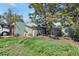 View of the back of the home with large trees and overgrown grass at 358 S Osceola St, Denver, CO 80219