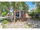 Charming home nestled among mature trees, with inviting front porch and landscaped yard with rock details at 358 S Osceola St, Denver, CO 80219