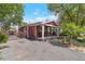 Inviting home with a quaint front porch, gravel driveway and artistic gate and landscaped yard with rock details at 358 S Osceola St, Denver, CO 80219