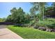 Lush backyard with grass and trees, leading up to elevated garden at 7822 W Ottawa Pl, Littleton, CO 80128