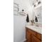Charming half bathroom with wooden vanity, decorative mirror, and stylish lighting fixtures at 7822 W Ottawa Pl, Littleton, CO 80128