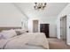 Bright bedroom featuring a neutral color palette, chandelier, and plush bedding at 7822 W Ottawa Pl, Littleton, CO 80128