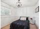 Cozy bedroom featuring modern light fixture and wainscoting at 7822 W Ottawa Pl, Littleton, CO 80128