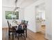 Elegant dining room with hardwood floors, bright windows, and modern light fixture next to kitchen area at 7822 W Ottawa Pl, Littleton, CO 80128