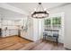 Eat-in kitchen featuring white cabinets, stainless steel appliances, wood floors, and large bright window at 7822 W Ottawa Pl, Littleton, CO 80128