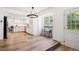 Eat-in kitchen featuring white cabinets, stainless steel appliances, wood floors, and large bright window at 7822 W Ottawa Pl, Littleton, CO 80128