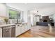 Well-lit kitchen flows into living area with a fireplace, hardwood floors, and stainless steel appliances at 7822 W Ottawa Pl, Littleton, CO 80128