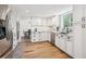 Bright kitchen with white cabinets, stainless steel appliances, hardwood floors and black hardware throughout at 7822 W Ottawa Pl, Littleton, CO 80128