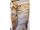 Upgraded shower with river rock floor and custom earth-toned tile surround at 7822 W Ottawa Pl, Littleton, CO 80128