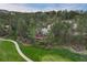 Aerial shot showcasing a stunning home nestled among lush trees, overlooking a well-manicured golf course at 120 Silver Leaf Way, Castle Rock, CO 80108