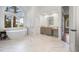 A bright bathroom with marble tile floors, a soaking tub, and a large arched window at 120 Silver Leaf Way, Castle Rock, CO 80108