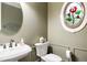 Stylish powder room with a pedestal sink, decorative mirror, and stained glass window at 120 Silver Leaf Way, Castle Rock, CO 80108