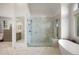 Bright bathroom with marble tile, glass enclosed shower with bench, and soaking tub at 120 Silver Leaf Way, Castle Rock, CO 80108