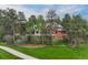Stately brick home surrounded by lush greenery, with a sprawling lawn and inviting curb appeal for a welcoming entrance at 120 Silver Leaf Way, Castle Rock, CO 80108