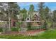 Stunning exterior home view surrounded by lush greenery, trees, and well-maintained yard at 120 Silver Leaf Way, Castle Rock, CO 80108