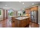 Bright kitchen with two islands, granite countertops, stainless appliances, and large windows overlooking a lush backyard at 120 Silver Leaf Way, Castle Rock, CO 80108