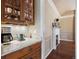 Butler's pantry with granite countertop, under cabinet lighting, and view into a dining room with fireplace at 120 Silver Leaf Way, Castle Rock, CO 80108