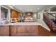 Spacious kitchen featuring hardwood floors, granite countertops, wood cabinets, stainless appliances and nearby stairway at 120 Silver Leaf Way, Castle Rock, CO 80108