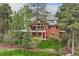 An exterior shot shows a brick home with multiple patios overlooking a golf course at 120 Silver Leaf Way, Castle Rock, CO 80108