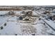 Aerial view of a home with a large, snow-covered backyard and white fencing at 9904 E 161St Pl, Brighton, CO 80602