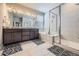 Bright bathroom featuring dual vanity, soaking tub, and glass-enclosed shower with white tile surround at 9904 E 161St Pl, Brighton, CO 80602