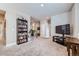 Spacious hallway with a full bookshelf and view of the entryway at 9904 E 161St Pl, Brighton, CO 80602