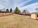 Large, fenced backyard with shed, garden beds, and mature trees at 6523 S Field Way, Littleton, CO 80123