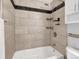 Bathtub and shower combo featuring tile surround and modern fixtures at 6523 S Field Way, Littleton, CO 80123