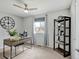 Bright bedroom features a ceiling fan, modern desk, and shelving unit for storage and display at 6523 S Field Way, Littleton, CO 80123