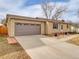 Suburban single-Gathering house with attached garage and double-wide concrete driveway and brick and vinyl siding at 6523 S Field Way, Littleton, CO 80123