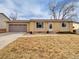 Charming ranch-style home featuring a two-car garage, xeriscaping, and neutral brick and siding at 6523 S Field Way, Littleton, CO 80123