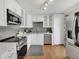 Modern kitchen featuring white cabinets, stainless steel appliances, and hardwood floors at 6523 S Field Way, Littleton, CO 80123