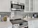 Detailed view of the kitchen featuring a stainless steel microwave and modern quartz countertops at 6523 S Field Way, Littleton, CO 80123