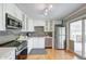 Well-lit kitchen featuring stainless steel appliances, white cabinets, and gray subway tile backsplash at 6523 S Field Way, Littleton, CO 80123