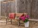 Cozy backyard bench with flower accents and striped pillows on a bed of stones at 5995 Estes St, Arvada, CO 80004