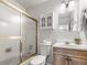 This bathroom features a toilet, vanity and shower with glass doors at 5995 Estes St, Arvada, CO 80004