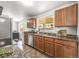 Bright kitchen featuring tile floors, granite countertops, and wooden cabinets at 5995 Estes St, Arvada, CO 80004
