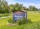Hoskinson Park sign surrounded by vibrant greenery and trees, set against a blue sky at 5995 Estes St, Arvada, CO 80004