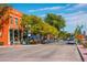 Bustling street view with colorful buildings, outdoor dining, and mature trees lining the sidewalks at 5995 Estes St, Arvada, CO 80004