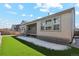 Backyard featuring synthetic grass, a covered patio, and large windows on the house offering a view of the outdoors at 17163 Desert Wine Trl, Parker, CO 80134