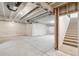 Unfinished basement with exposed ceiling, white walls, concrete floors, and stairs leading to the upper level at 17163 Desert Wine Trl, Parker, CO 80134